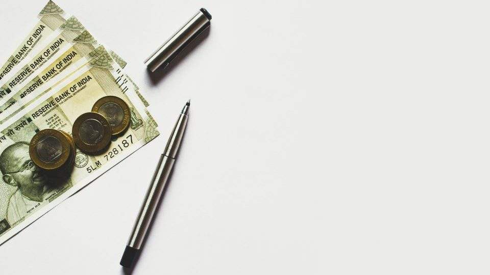 cash notes laying next to pen