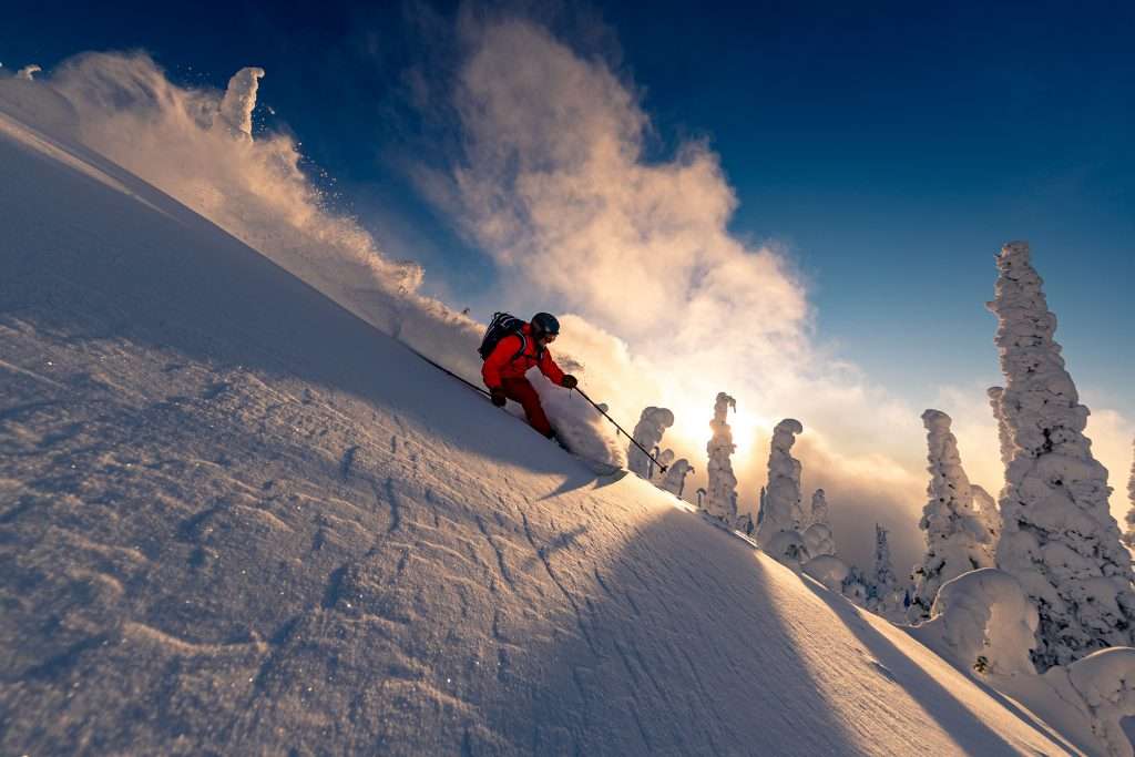 skier in red jacket turning in powder