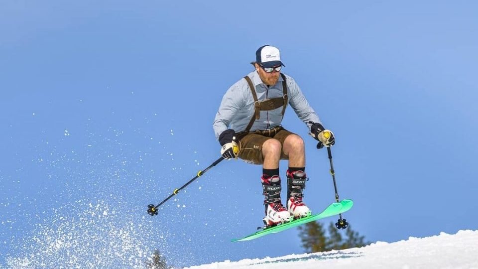 Jari jumping on skis in Laderhosen