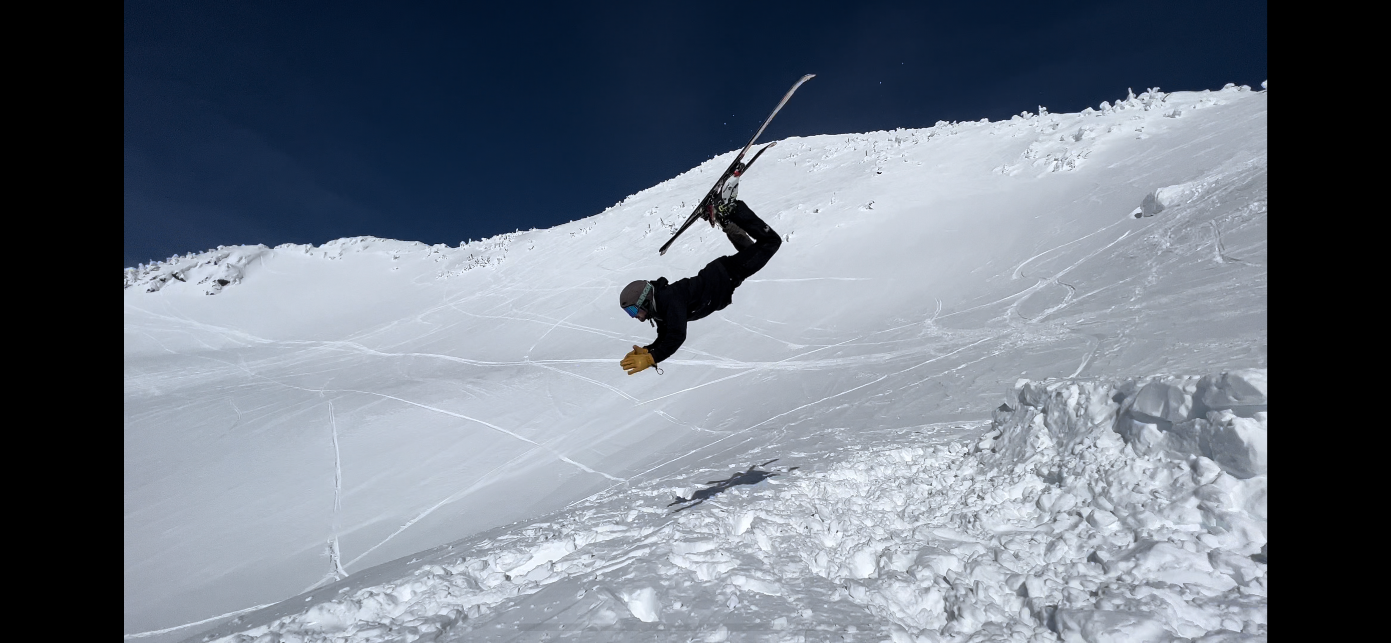 skier in mid flight upside down about to land