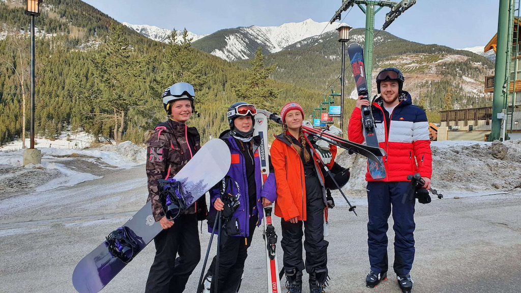 4 skiers standing with equipment doing a ski season